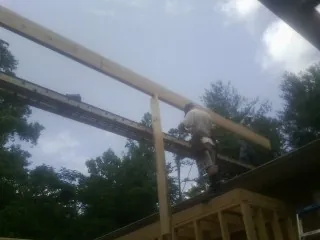 Carpenter setting a ridge beam over a new addition frame — Ice Dam Removal by Roofing Brothers in Pittsboro