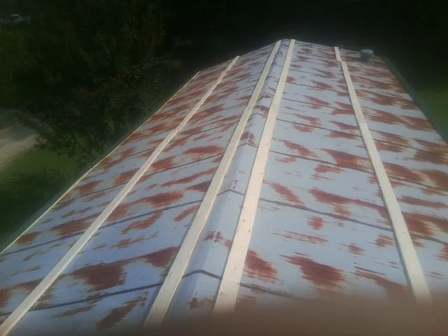 Rusted metal roof panels with new wood purlins before replacement — Storm Damage Roof Repair in Pittsboro by Roofing Brothers