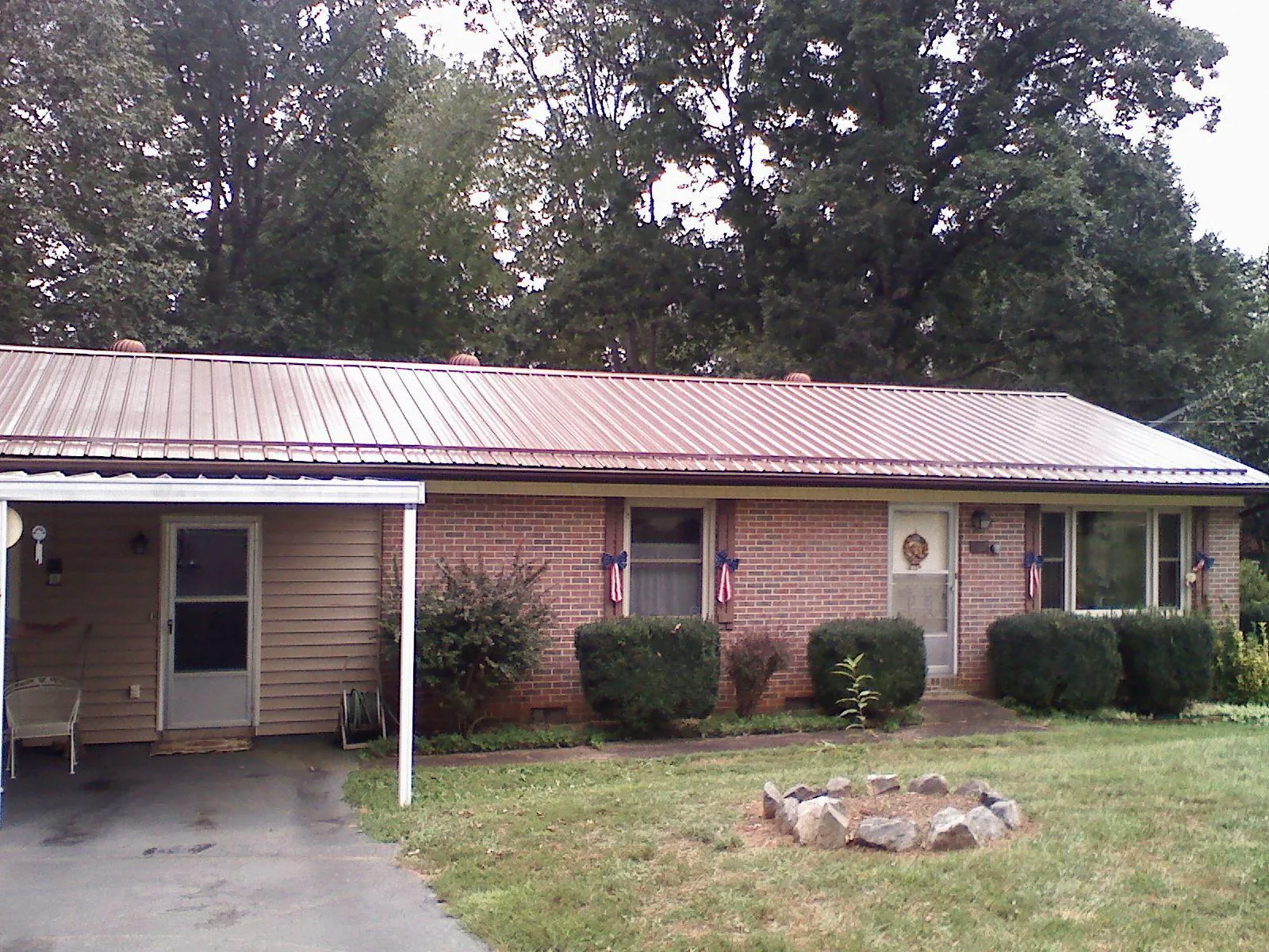 Bronze metal roof and carport on a brick ranch home — Roof Repair work by our crew in Pittsboro